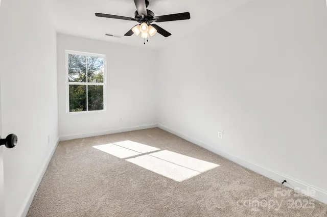 a view of a livingroom with a ceiling fan and window