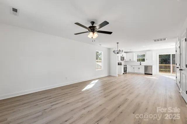 a view of a livingroom with wooden floor and a ceiling fan