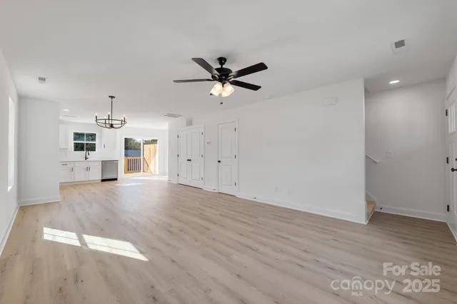 a view of a kitchen with wooden floor and a ceiling fan