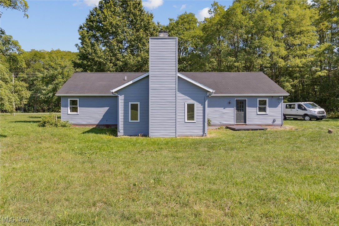 3930 Wood Road Madison, OH 44057 - Photo 43 of 45 Rear view of house with a yard and a chimney