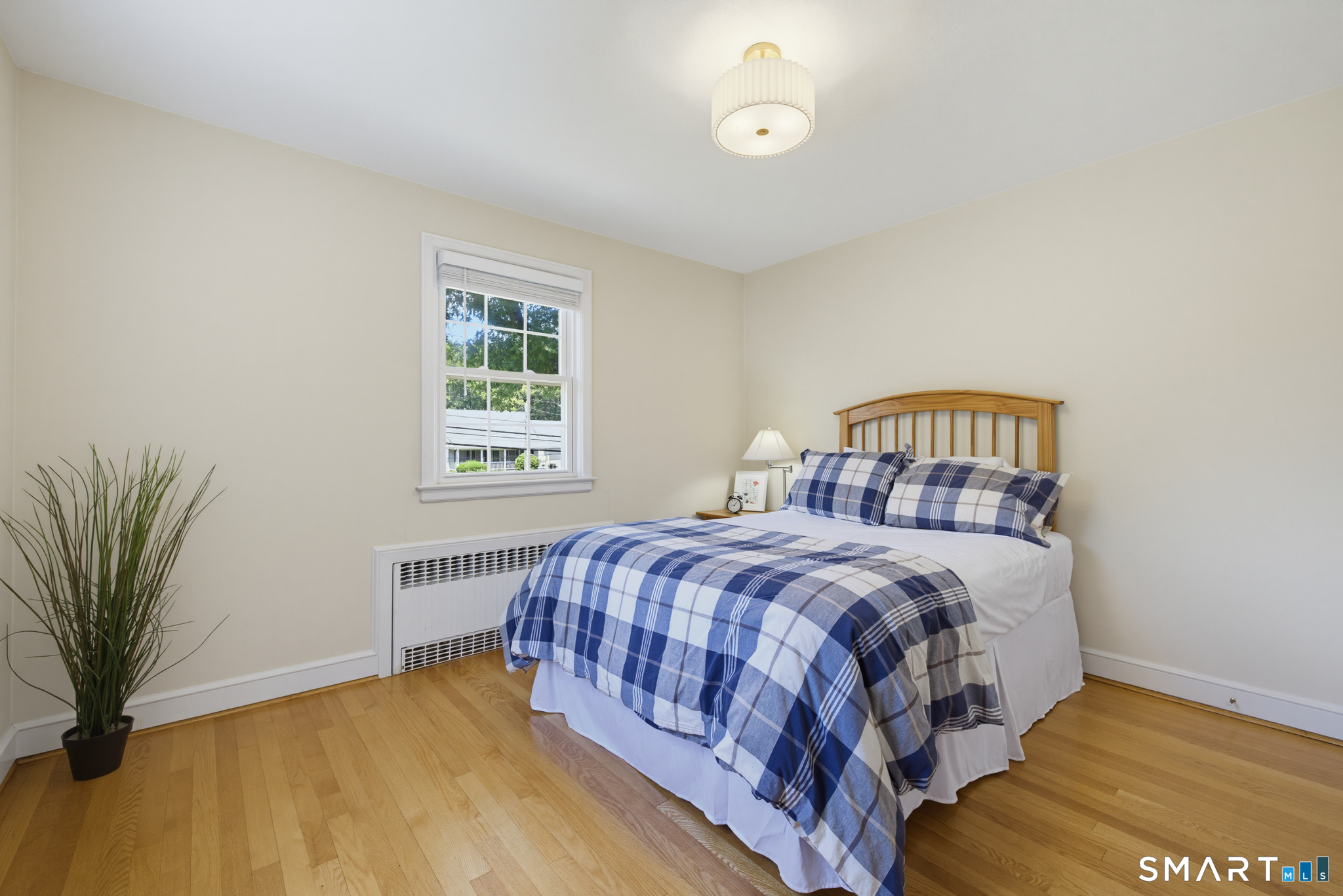 224 Spring Street Manchester, CT 06040 - Photo 26 of 39 a bedroom with a bed lamp and a potted plant