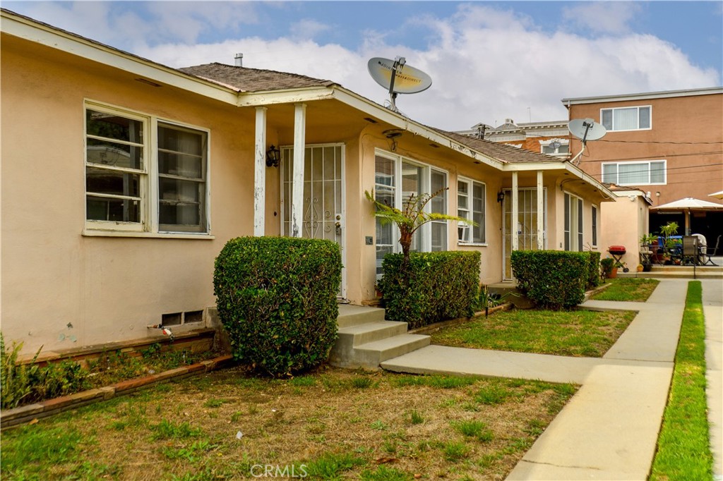 12817 Beverly Boulevard Whittier, CA 90601 - Photo 11 of 30 a view of a brick house with a yard plants and large tree