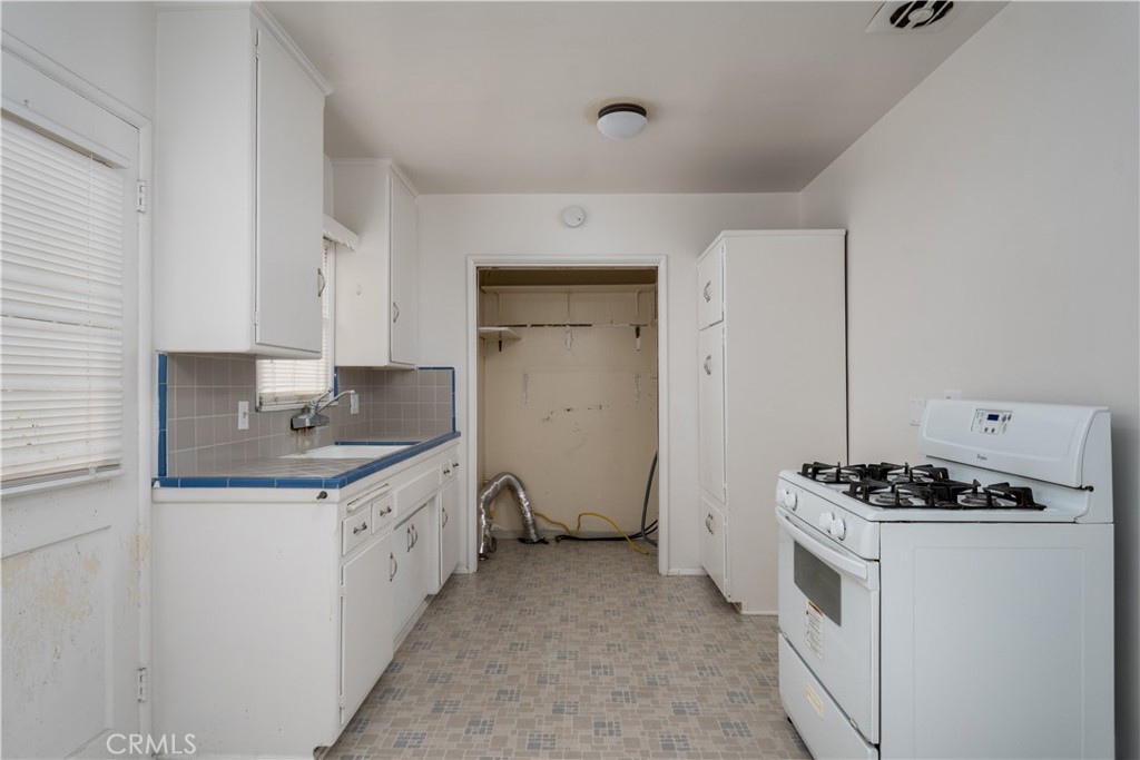 12817 Beverly Boulevard Whittier, CA 90601 - Photo 14 of 30 a kitchen with granite countertop a sink stove and cabinets