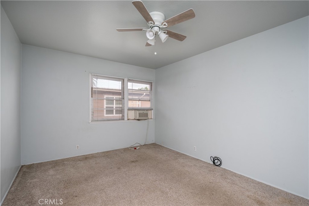 12817 Beverly Boulevard Whittier, CA 90601 - Photo 16 of 30 an empty room with a chandelier fan and windows