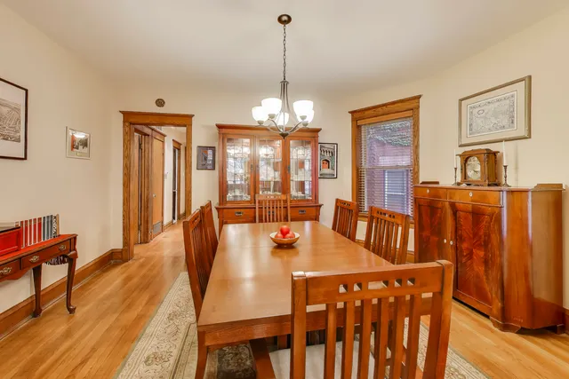 a dining room with furniture a chandelier and wooden floor