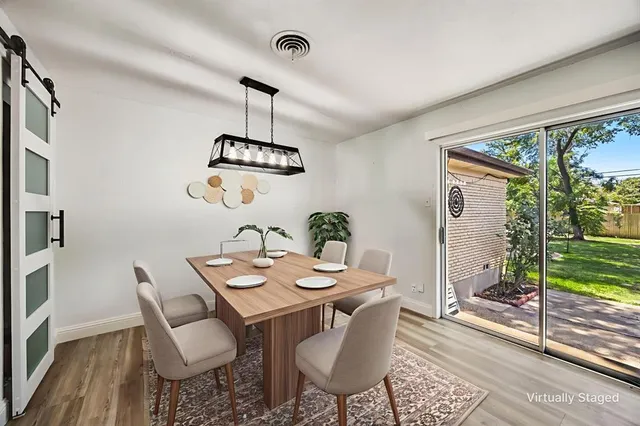 a dining room with furniture a chandelier and wooden floor