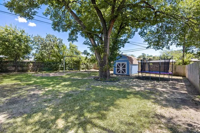 a view of a house with backyard and tree