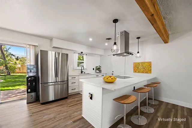 a kitchen with a sink a refrigerator and a stove top oven