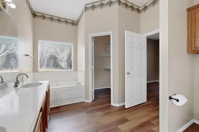 a bathroom with a tub sink and mirror