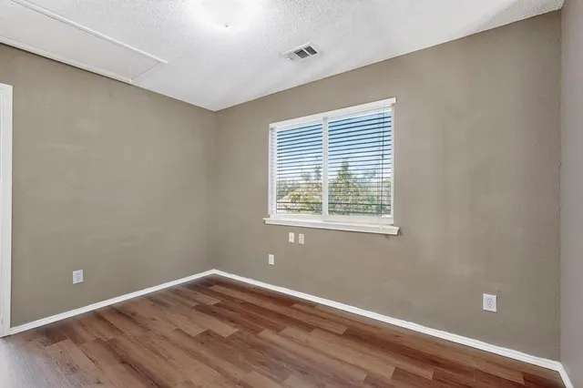 a view of a room with wooden floor and windows