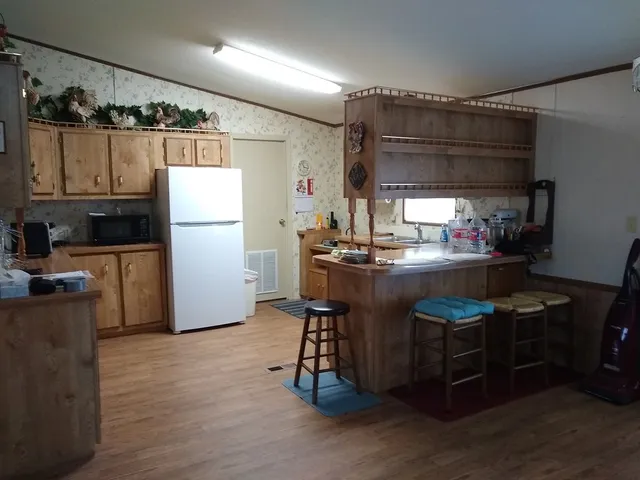 a kitchen with stainless steel appliances granite countertop a sink refrigerator and cabinets