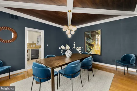 a kitchen with stainless steel appliances kitchen island granite countertop a stove a sink and white cabinets with wooden floor