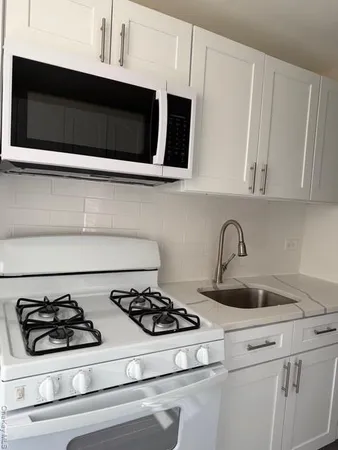 a kitchen with stove a microwave and cabinets