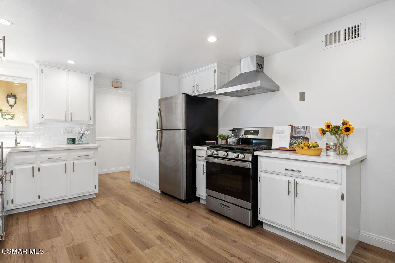 3359 Ridden Street Camarillo, CA 93010 - Photo 15 of 30 a kitchen with granite countertop a refrigerator stove and white cabinets