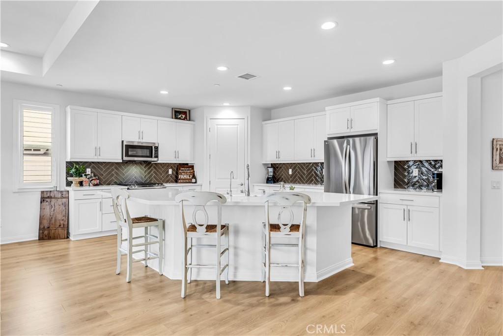 a kitchen with white cabinets and stainless steel appliances