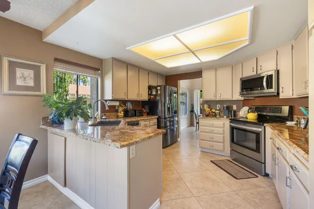 a kitchen with granite countertop a large window and a counter space