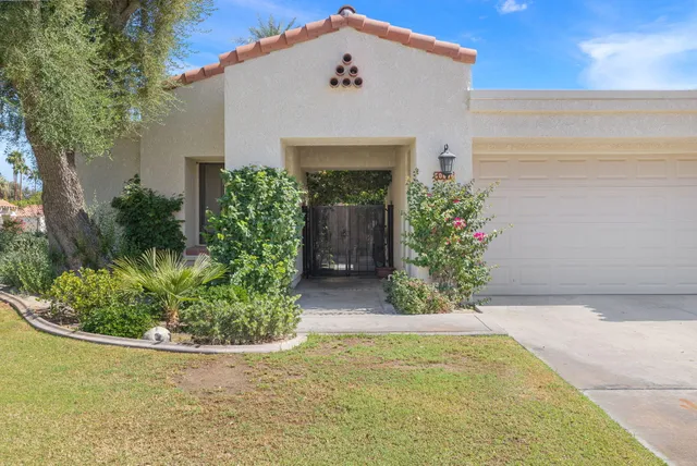 a view of a patio with table and chairs potted plants and large tree