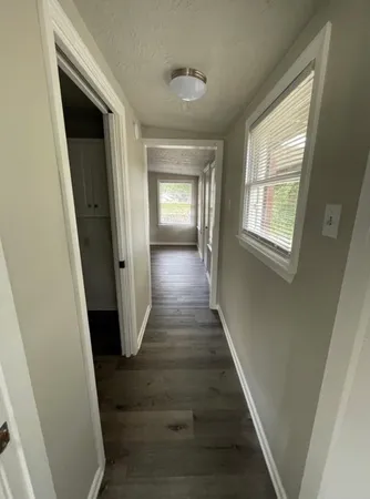 a view of a hallway with wooden floor and stairs