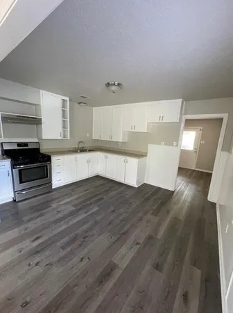 a kitchen with wooden floors and white walls