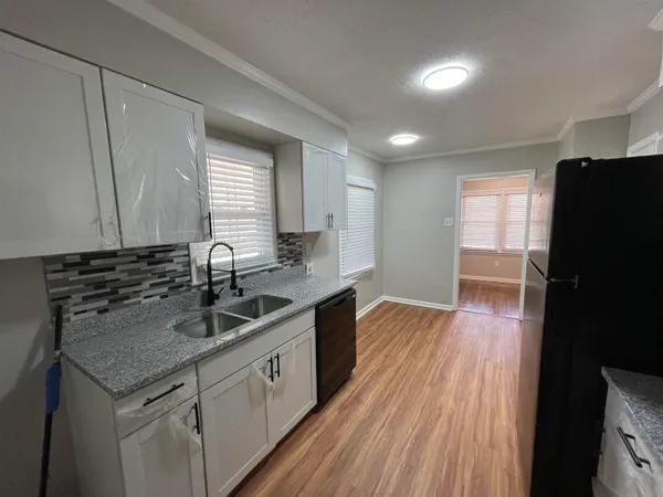 a kitchen with granite countertop a sink stove and refrigerator