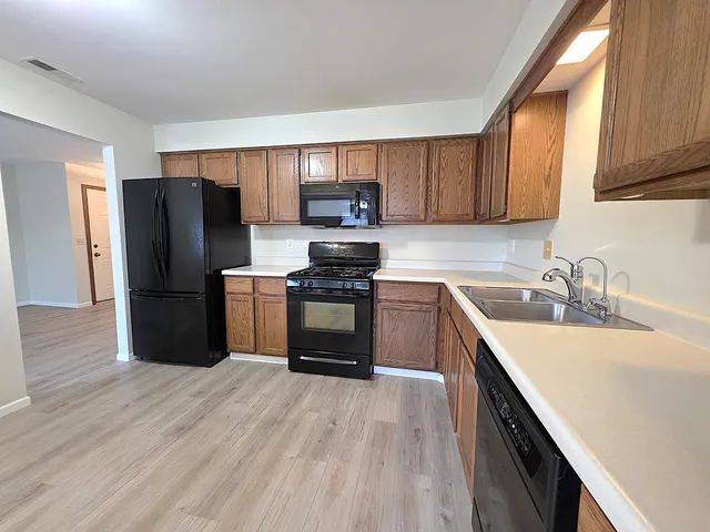 a kitchen with granite countertop a refrigerator stove top oven and sink