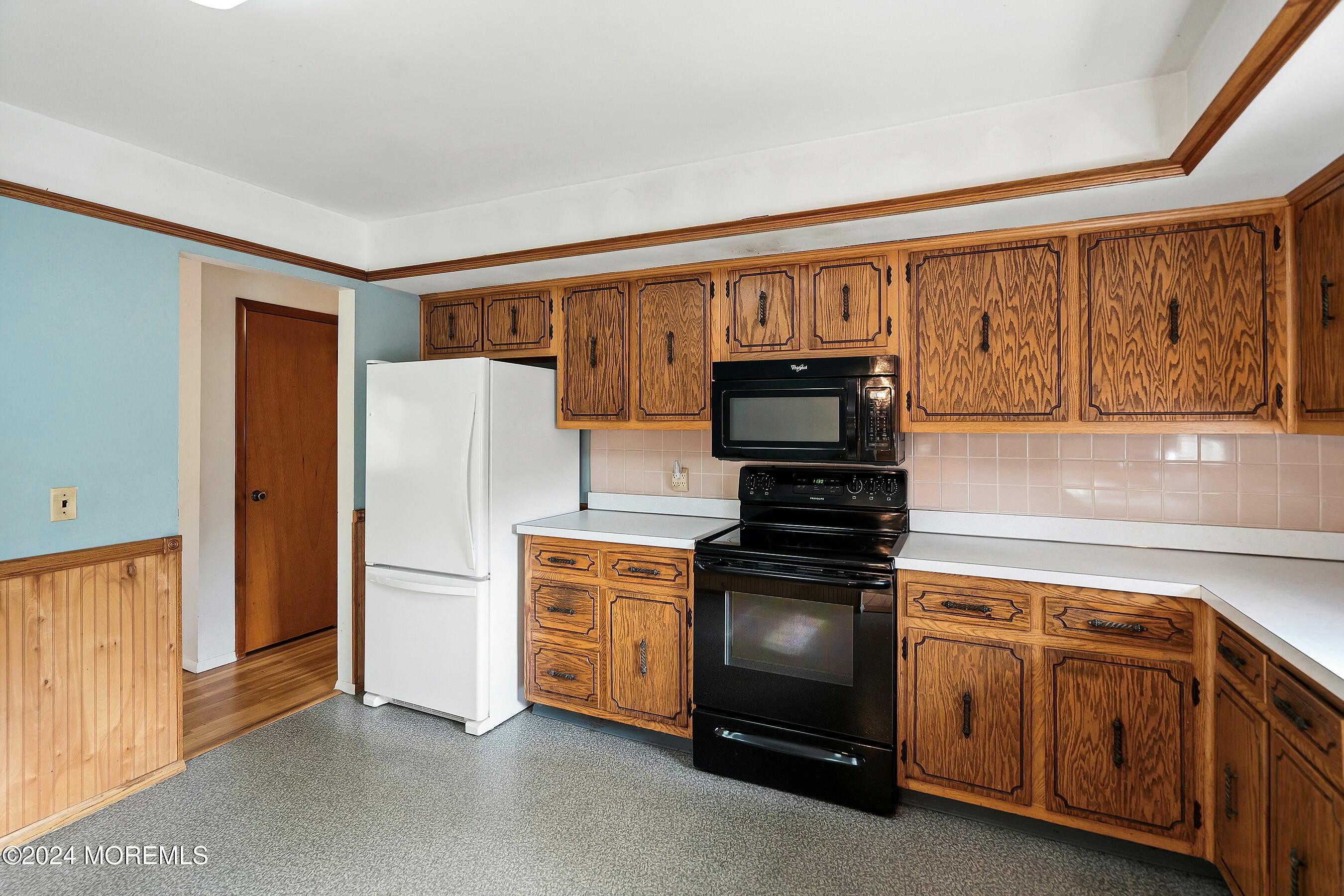 1107 Manito Road Manasquan, NJ 08736 - Photo 8 of 27 a kitchen with wooden cabinets and a stove top oven