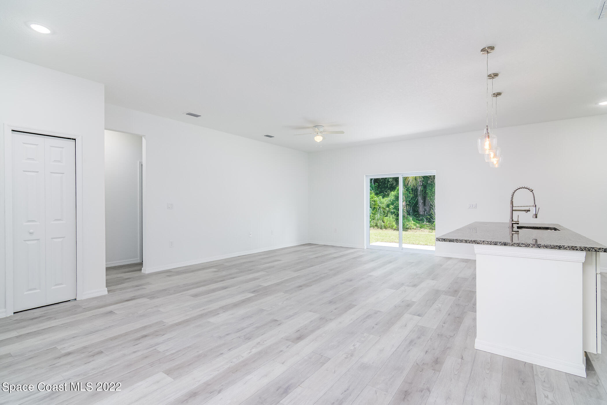 399 Taunton Road Southwest Palm Bay, FL 32908 - Photo 15 of 43 a view of an empty room with a window and wooden floor