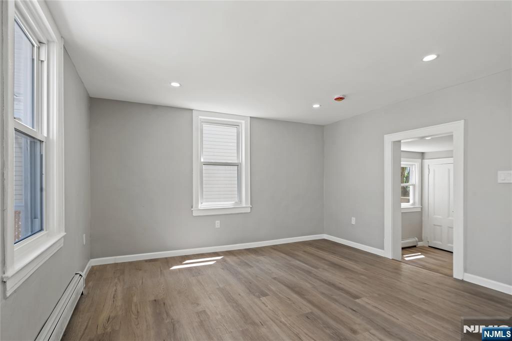 190 Washington Avenue Hackensack, NJ 07601 - Photo 5 of 20 an empty room with wooden floor and windows