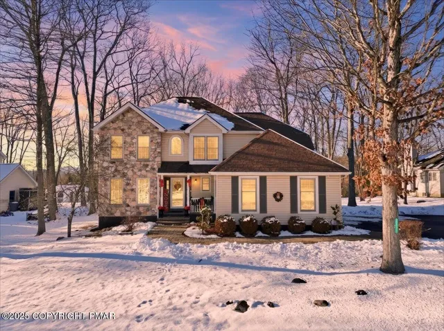 a front view of a house with a yard covered in snow
