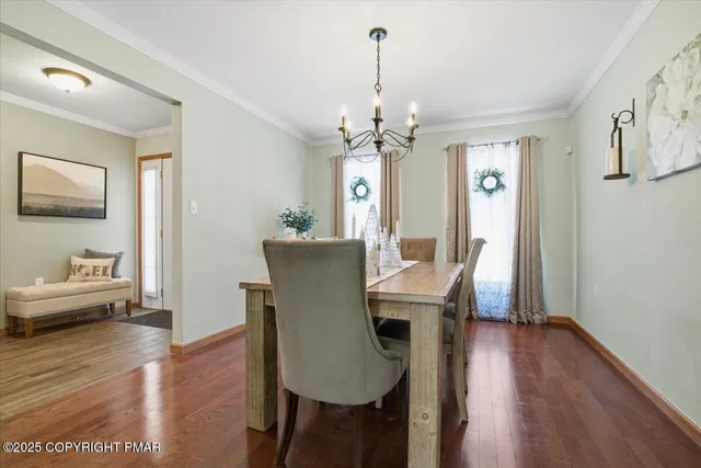 a view of a dining room with furniture wooden floor and a chandelier