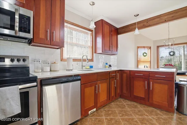 a kitchen with stainless steel appliances granite countertop a sink stove and microwave