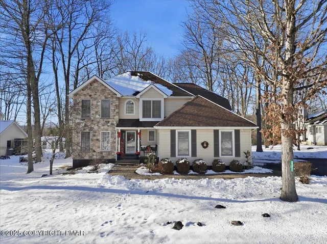 a front view of a house with a yard covered in snow