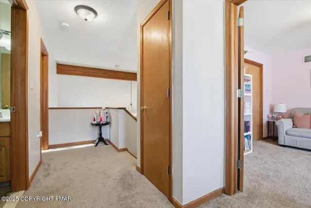 a view of a hallway with a view of bedroom with a large window