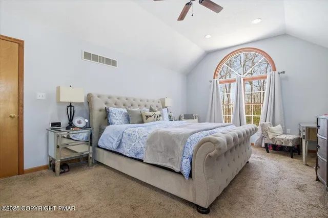 a spacious bedroom with a bed and a mirror