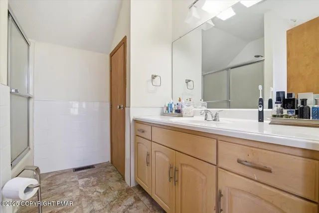 a bathroom with a sink and a mirror white cabinets