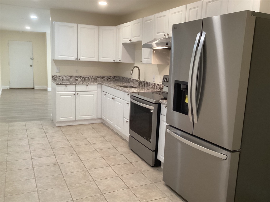 566 Commonwealth Avenue, Unit 101 Boston, MA 02215 - Photo 2 of 17 a kitchen with stainless steel appliances granite countertop a refrigerator and a sink