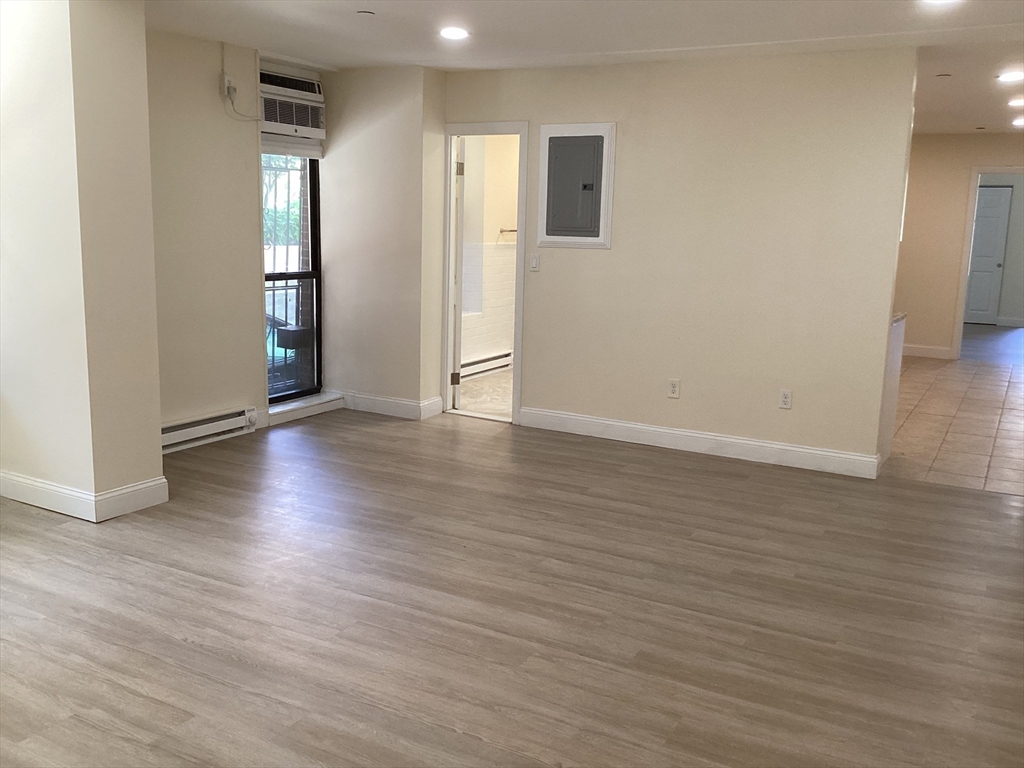 566 Commonwealth Avenue, Unit 101 Boston, MA 02215 - Photo 5 of 17 a view of an empty room with wooden floor and a window