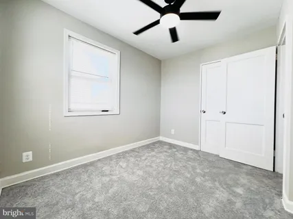 an empty room with a window and a fan