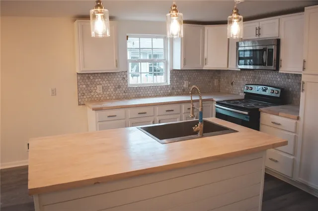 a kitchen with granite countertop a sink and a stove top oven
