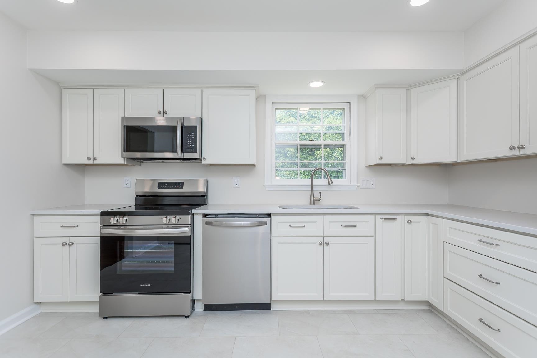 1002 North Coalter Street Staunton, VA 24401 - Photo 15 of 36 a kitchen with white cabinets stainless steel appliances and window