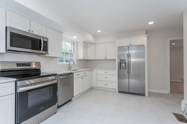 a kitchen with stainless steel appliances granite countertop a stove a sink and a microwave