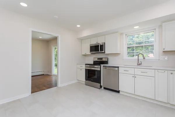 a kitchen with cabinets stainless steel appliances and window