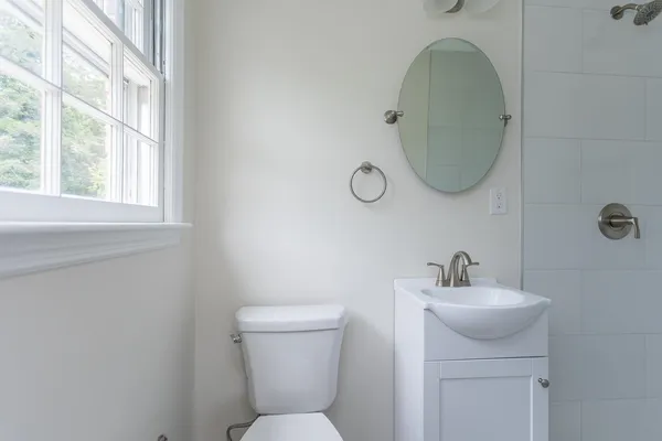 a bathroom with a toilet sink and mirror