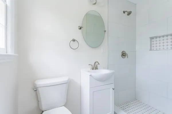 a bathroom with a toilet a sink and mirror