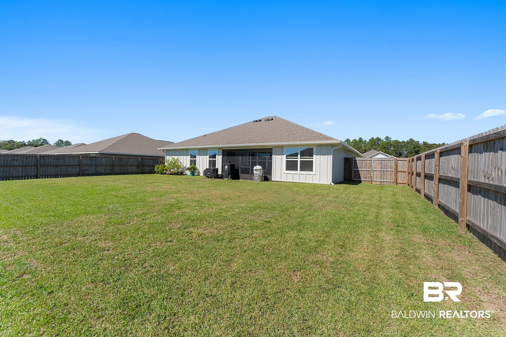 24337 Ringneck Loop Elberta, AL 36530 - Photo 33 of 34 Back of house with board and batten siding and a fenced backyard