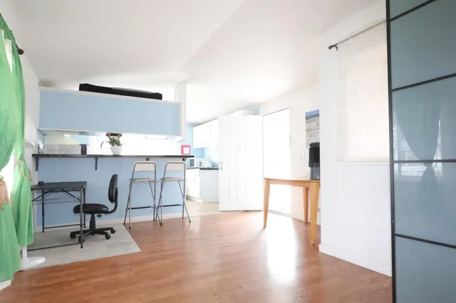 a view of a workspace with furniture and a window