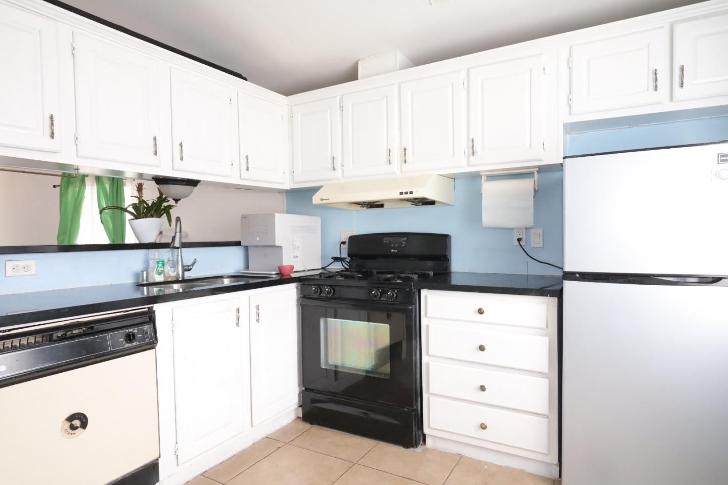 60 Wilson Way, Unit 150 Milpitas, CA 95035 - Photo 8 of 12 a kitchen with granite countertop white cabinets and white appliances
