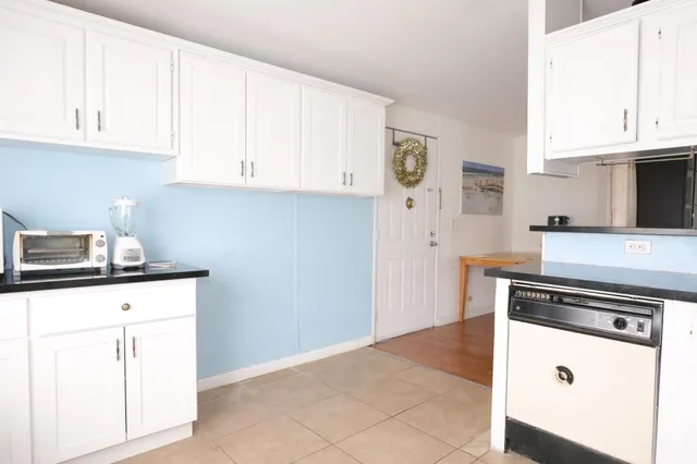 a kitchen with granite countertop white cabinets and white appliances