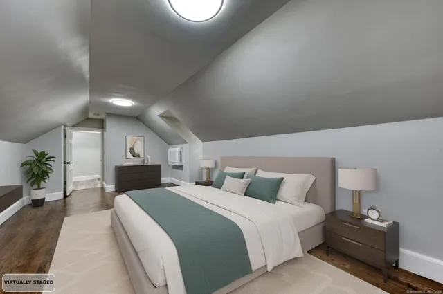 a spacious bedroom with a bed and lamp on table