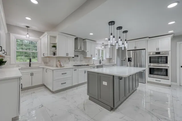 a kitchen that has a lot of cabinets in it and stainless steel appliances